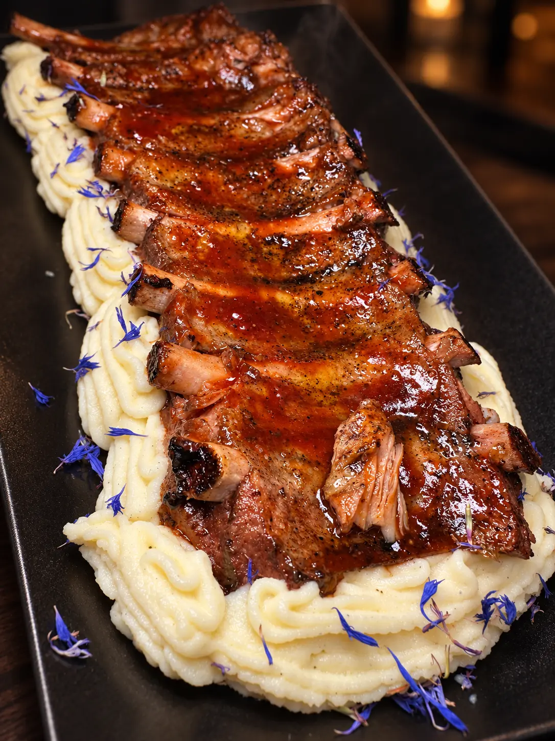 Ribs di maiale glassate servite su purea